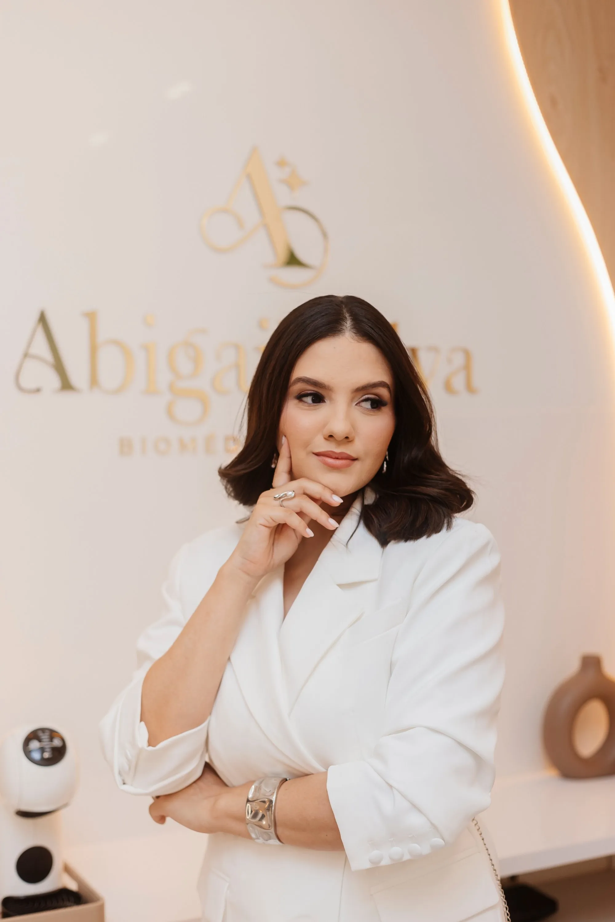 Retrato da Dra. Abigail Silva em frente à marca da clínica